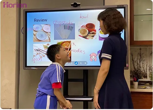 A primary school pupil and a teacher at a Horion interactive panel during a lesson