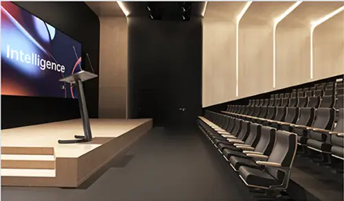 Auditoriyada ma’ruzachi Horion aqlli minbaridan katta LED ekranga taqdimot uzatmoqda