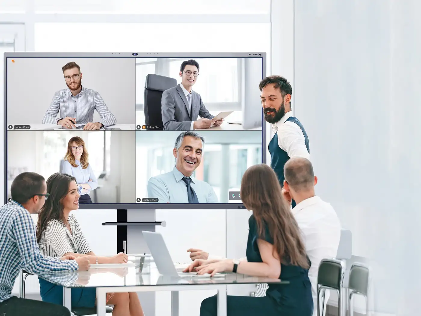 A team of four in a meeting room talking to remote colleagues via a Horion panel